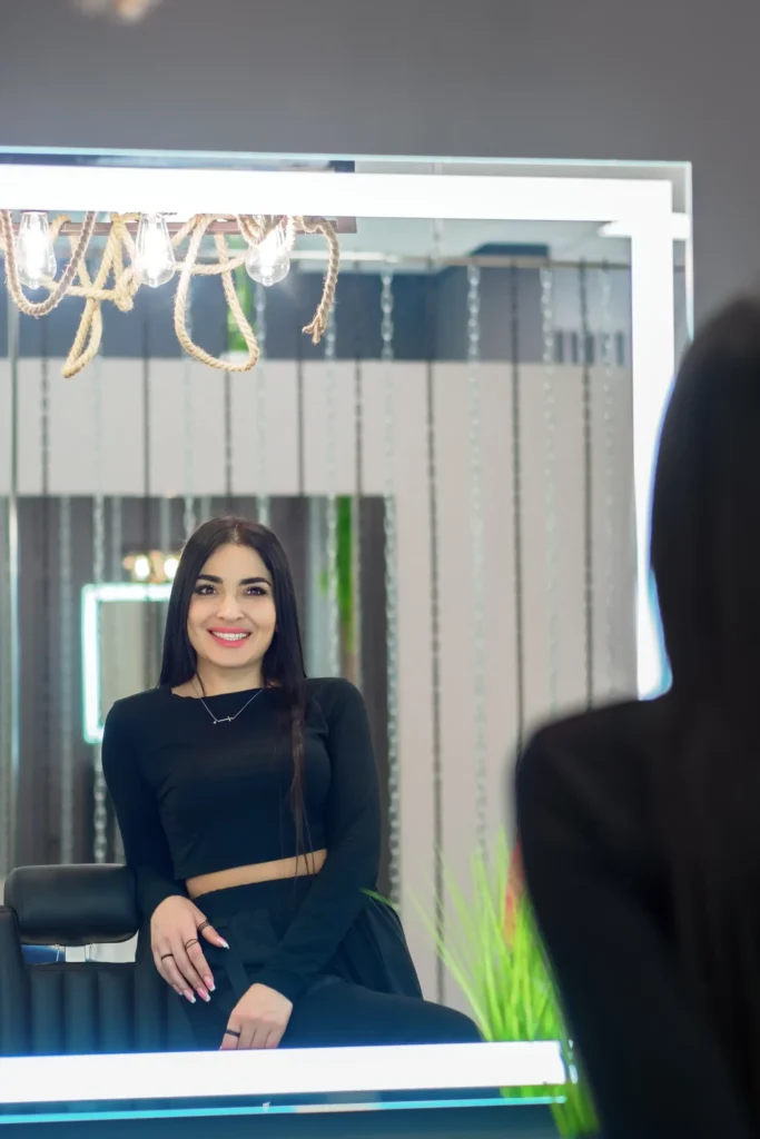 Woman smiling in salon mirror reflection