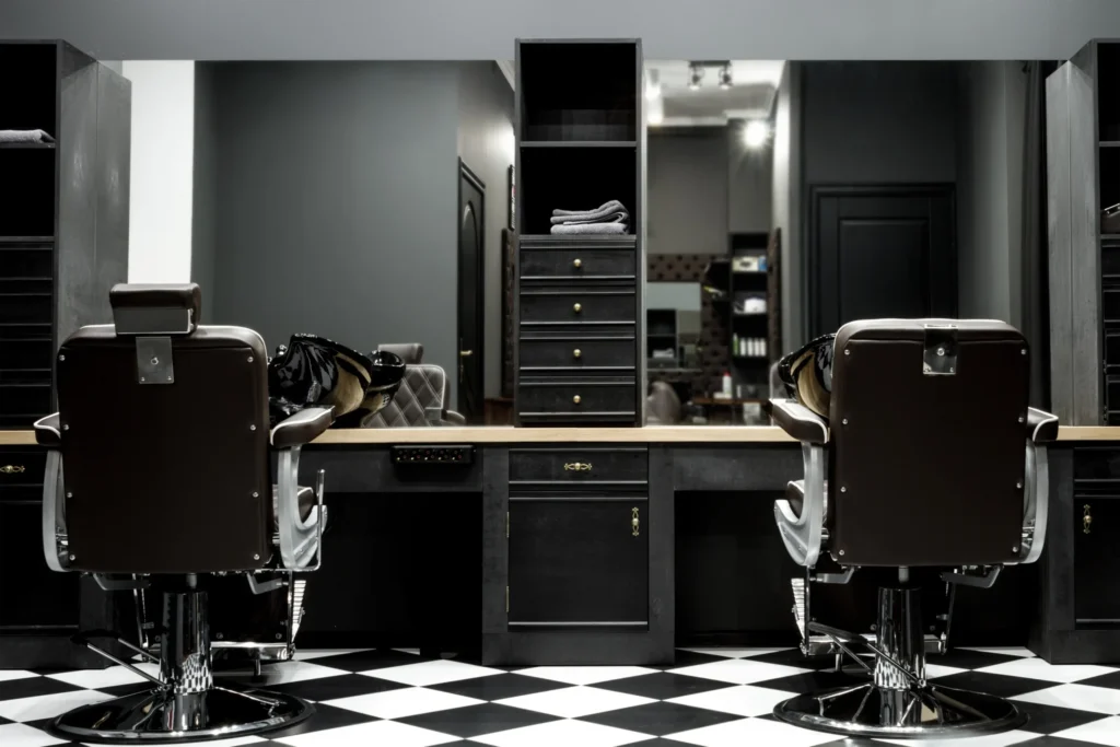 Modern barbershop with two styling chairs and mirrors.